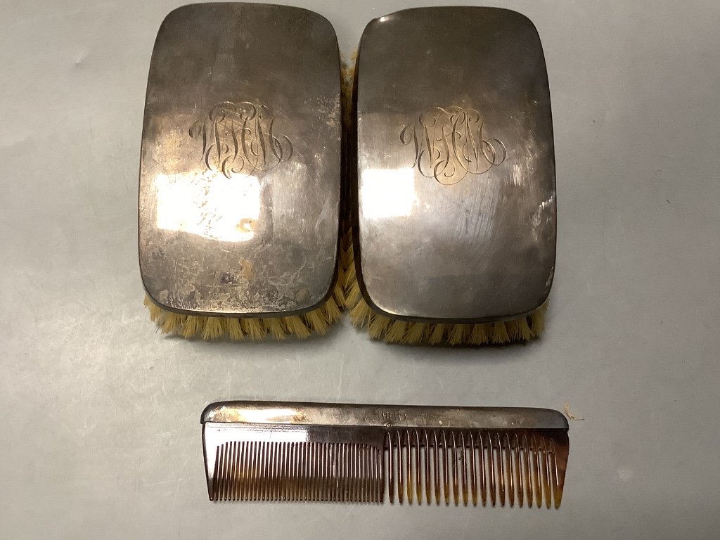 A cased pair of silver mounted clothes brushes, a cased silver spoon and pusher and a cased set a silver bean end coffee spoons.